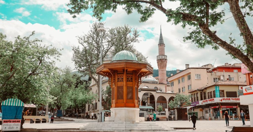 Charming town square with traditional architecture and mosque in a lively urban setting.
