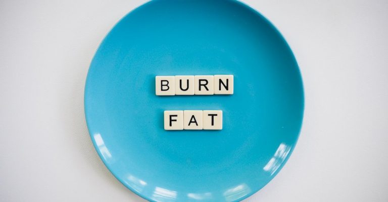 A conceptual image featuring the words 'Burn Fat' on a blue plate, symbolizing weight loss.