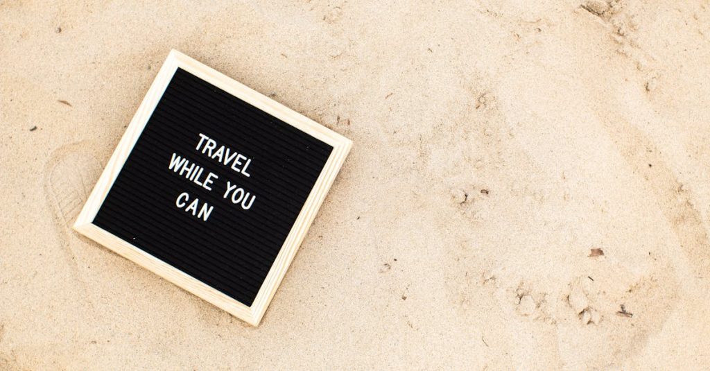 Letter board with 'Travel While You Can' message displayed on sandy beach scene, inspiring wanderlust.