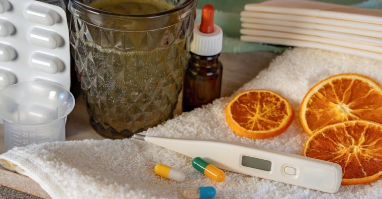 A flat lay of home remedies for cold and flu, featuring herbs and pharmaceuticals.