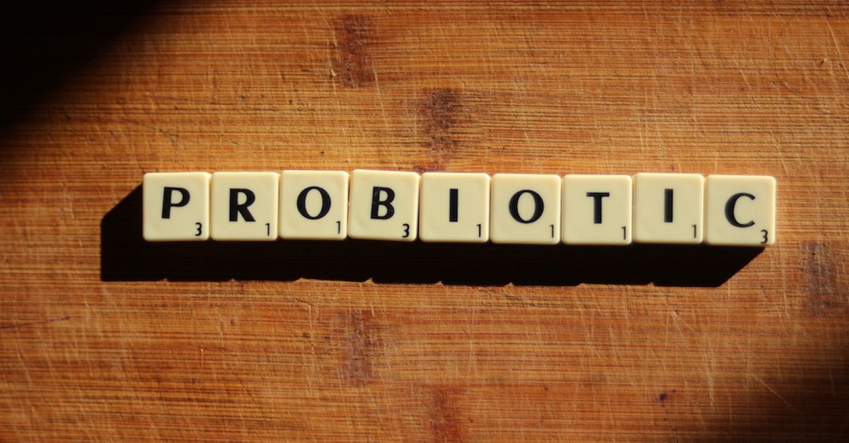 Close-up of the word 'probiotic' crafted from letter tiles on a wooden surface.