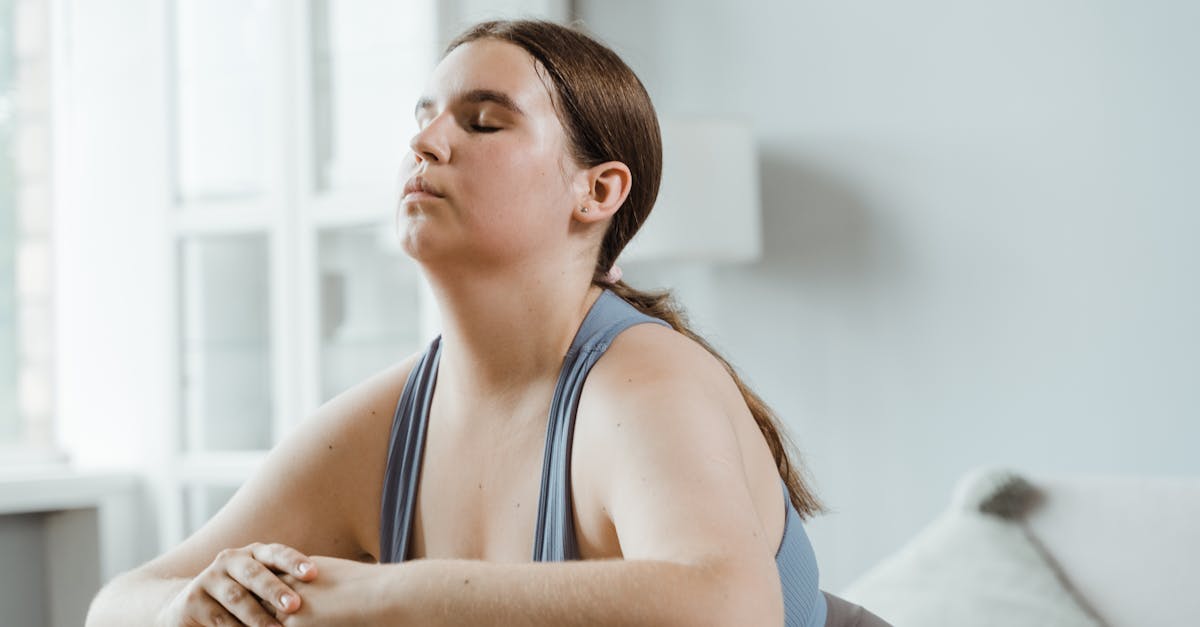 A plus size woman practicing yoga indoors with focus on wellness and relaxation.
