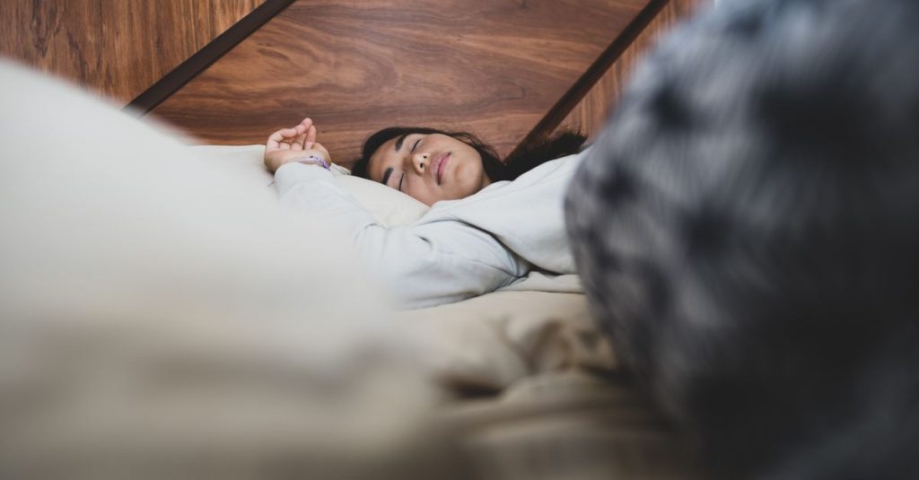 A woman peacefully sleeping on a bed, conveying relaxation and comfort.